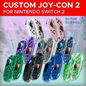 Puede incluir: Mandos Custom Joy-Con 2 para Nintendo Switch 2 en varios colores. La imagen muestra múltiples pares de mandos en blanco, rosa, transparente, morado, verde, negro y azul. Cada mando tiene botones y joysticks de colores.