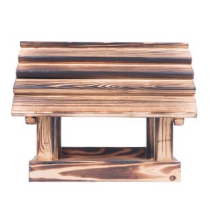 May include: A wooden bird feeder with a slatted roof and a rectangular base. The wood has a natural grain and a dark, burnt finish, giving it a rustic appearance. The feeder is designed to be mounted or placed in a garden.
