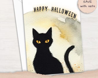 May include: A greeting card featuring a watercolor illustration of a black cat with bright yellow eyes against a pale yellow and gray moon-like background. The text "HAPPY HALLOWEEN" is printed in black at the top of the card.