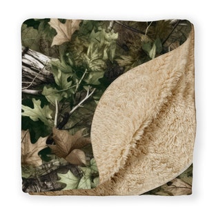 May include: A soft, plush blanket with a camouflage pattern on one side and a solid beige sherpa fleece on the other side.