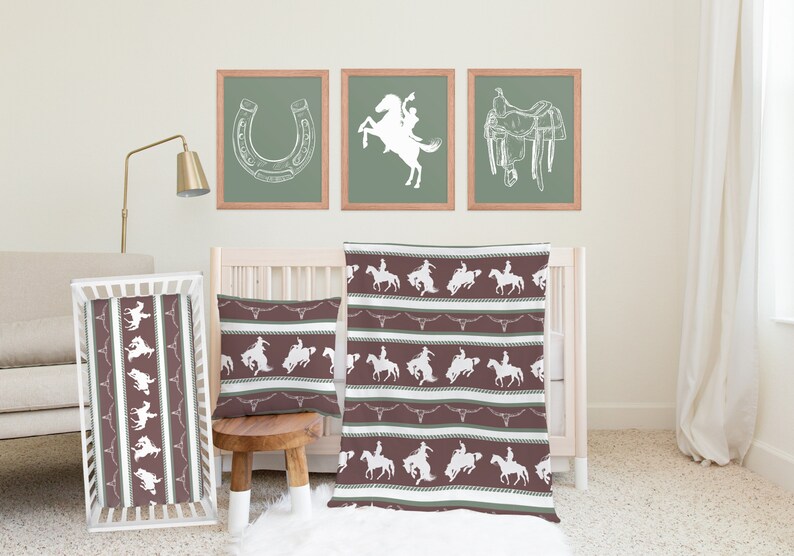May include: A brown and green baby crib bedding set with a cowboy theme. The set includes a crib sheet, a blanket, and a pillow. The bedding features a white silhouette of a cowboy riding a horse.