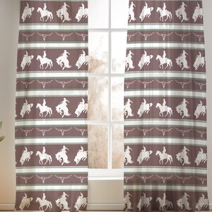 May include: A pair of sheer curtains with a repeating pattern of cowboys riding horses. The pattern is in white on a brown background with green accents.