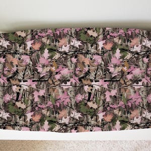 May include: Pink and green camouflage fabric with a leaf pattern. The fabric is perfect for crafting projects, home decor, and more.