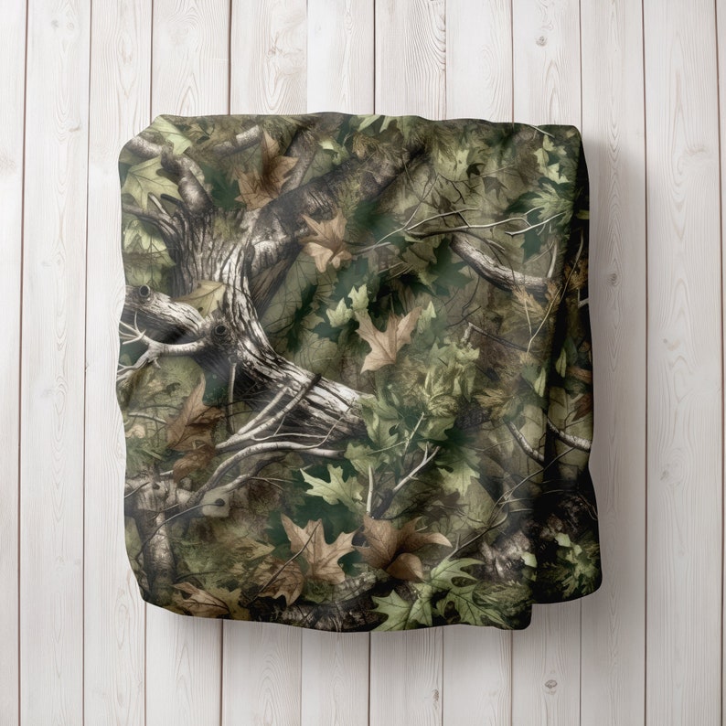 May include: Camouflage fabric with a green, brown and white pattern of leaves and branches.