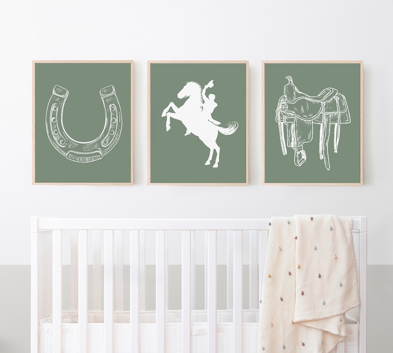 May include: Three framed prints with a green background and white illustrations of a horseshoe, a cowboy riding a horse, and a saddle.