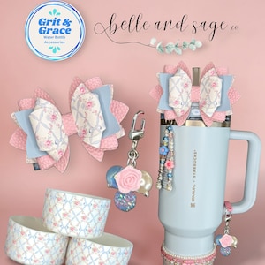 May include: Water bottle accessories in a pink and blue floral design, including bows, charms, and bands. The image shows a water bottle with accessories, and the text "Ribbon Rosettes", "Grit & Grace", and "belle and sage co.".