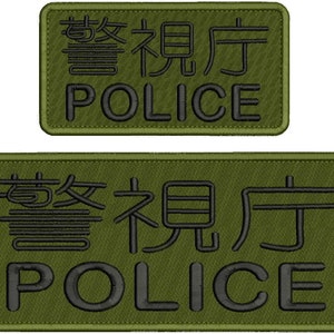 May include: Two rectangular olive green embroidered patches featuring black stitching. Each patch displays the Japanese kanji for Tokyo Metropolitan Police Department above the English word POLICE in a bold, sans-serif font.