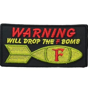 May include: A rectangular black embroidered patch featuring the red text WARNING and yellow text WILL DROP THE F BOMB. Below the text is a yellow bomb graphic with a red letter F in the center, designed with a pointed tail and rounded body.