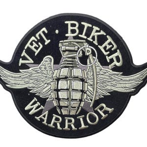 May include: A circular embroidered patch with a black background featuring a central light gray hand grenade with wings. The text VET BIKER WARRIOR is stitched in light gray capital letters around the perimeter of the circular design.