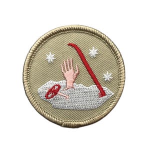 May include: A circular embroidered patch with a tan background and a stitched border. The design features a light pink hand emerging from a textured gray cloud, a red curved tool, and three small white star-like shapes scattered around the center.