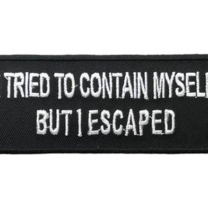 May include: A rectangular black embroidered patch with rounded corners featuring the white stitched text I TRIED TO CONTAIN MYSELF BUT I ESCAPED. The patch has a thick black border and a textured fabric surface with clear white lettering.