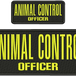 Peut inclure: Deux écussons rectangulaires noirs brodés aux coins arrondis. Le texte ANIMAL CONTROL est cousu en lettres capitales jaunes en gras, avec le mot OFFICER en plus petites lettres capitales jaunes juste en dessous sur les deux écussons.