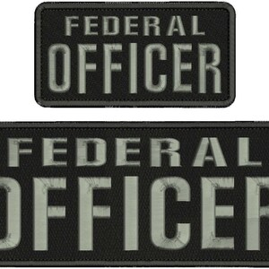 May include: Two rectangular embroidered patches with black fabric backgrounds and stitched borders. Each patch features the text FEDERAL OFFICER in bold, light gray, sans-serif capital letters, with the top patch being smaller than the bottom one.