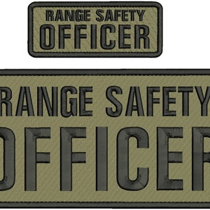 Può includere: Due toppe rettangolari ricamate color verde oliva con bordi neri. Ogni toppa presenta il testo RANGE SAFETY OFFICER in grassetto nero a caratteri maiuscoli, con la parola OFFICER in un carattere più grande rispetto a RANGE SAFETY.