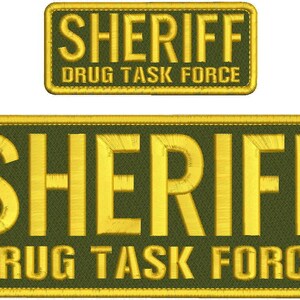 May include: Two rectangular embroidered patches with olive green fabric and yellow stitched borders. Both patches feature the word SHERIFF in large yellow letters above the text DRUG TASK FORCE in smaller yellow letters, all in a sans-serif font.