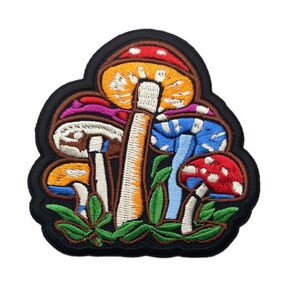 May include: An embroidered patch featuring a cluster of five mushrooms in vibrant colors including red, orange, yellow, blue, and white. The design includes green leaves at the base and is outlined with a thick black border on a white background.