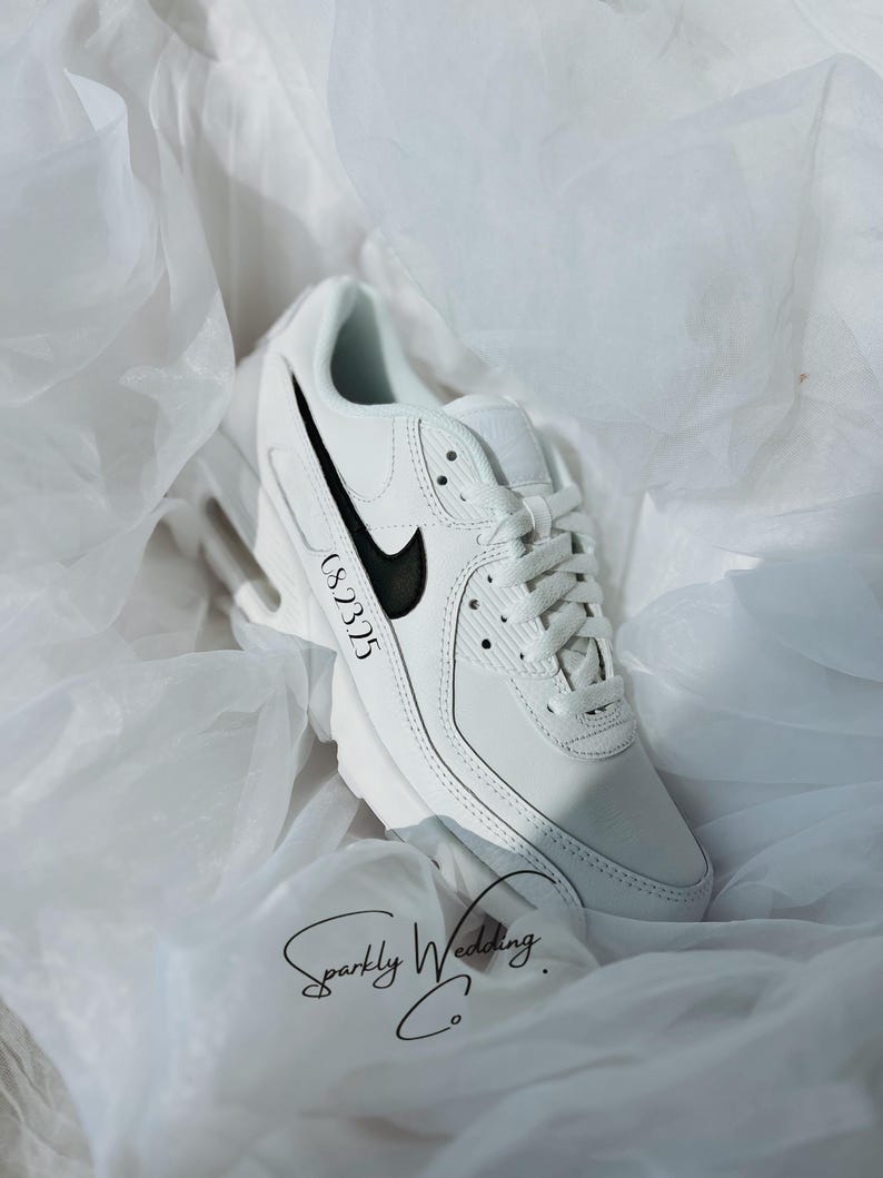 May include: White sneaker with a black swoosh and accents. The shoe has the text "CS 2325" on the side. The words "Sparkly Wedding Co." are written in cursive at the bottom.