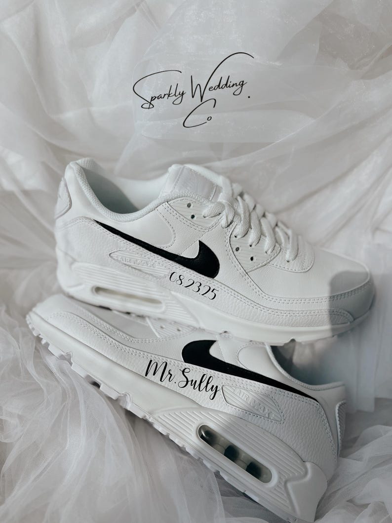 May include: White sneakers with black Nike swooshes and personalized text. One shoe reads "CS2325" and the other reads "Mr. Sully". The shoes are displayed on a white, textured surface, with the text "Sparkly Wedding Co." in the background.