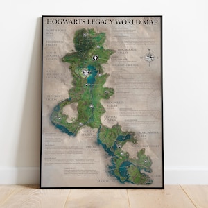 May include: A framed map of the Hogwarts Legacy world. The map features a detailed illustration of the game's landscape, including regions like the Forbidden Forest and Hogwarts Valley. The map is in a black frame and is displayed against a white wall.