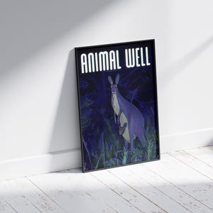 May include: A black framed poster with the text "ANIMAL WELL" in white letters. The poster features a purple kangaroo with a joey in its pouch standing in a dark green forest.