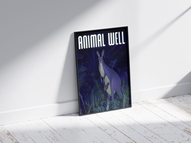 May include: A black framed poster with the text "ANIMAL WELL" in white letters. The poster features a purple kangaroo with a joey in its pouch standing in a dark green forest.