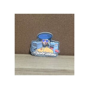 May include: A sticker featuring a cartoon illustration of a welder wearing blue sunglasses and a yellow jumpsuit, standing in front of welding equipment. The sticker has the text "Lincoln Welders" in a stylized font.