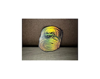 May include: A sticker of a roll of cash with a skull face wearing sunglasses. The sticker is a gradient of yellow, orange, and green. The text "Webshops1.Com" is on the sticker.