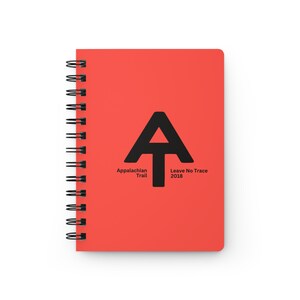May include: A red spiral bound notebook with a black Appalachian Trail logo and the text "Appalachian Trail" and "Leave No Trace 2018".