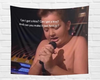 Puede incluir: Una persona joven canta en un micrófono con la letra "Can I get a kiss? Can I get a kiss? And can you make it last forever?"