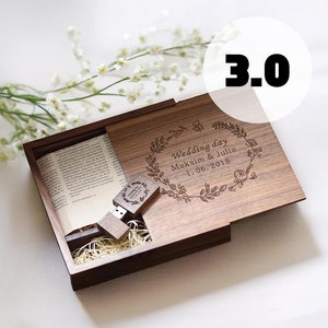 May include: A wooden box with a hinged lid, engraved with the text "Wedding day Maksim & Julia 1.06.2018" and a floral design. The box is open and contains a small wooden USB drive with a similar floral design.
