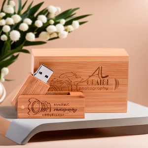 May include: A wooden USB drive with a camera design and the text "Rosita Photography" and phone number "0889815432" engraved on the front. The drive is in a wooden box with the text "Al Oraibi Photography" engraved on the lid.