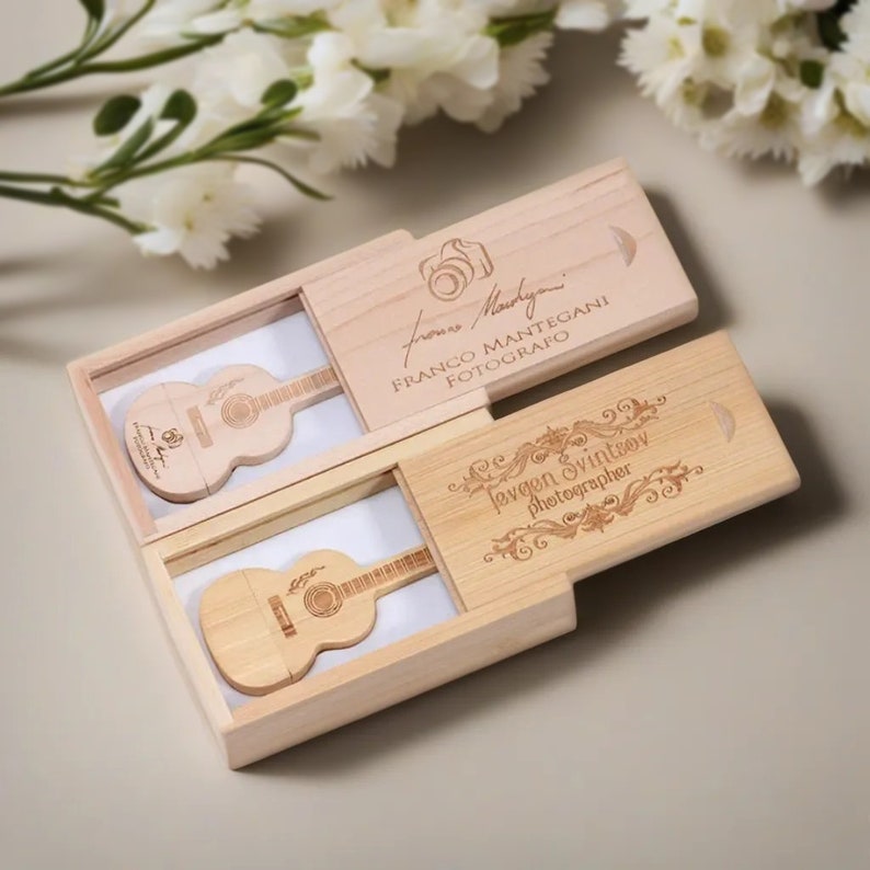 May include: Two wooden boxes with guitar-shaped USB drives inside. The boxes are engraved with the names "Franco Mantegani Fotografo" and "Evgen Svintov photographer".