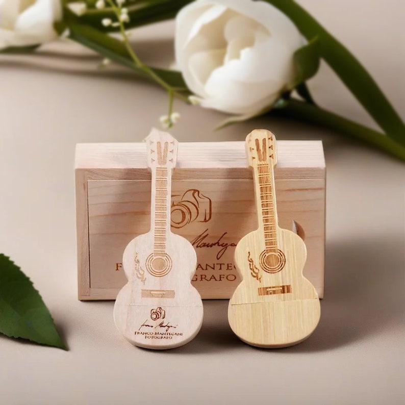 May include: Two wooden guitar-shaped USB drives in a wooden box. The drives are engraved with a guitar and the text "Franco Mantegani Fotografo".