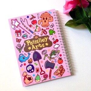 Image of the back cover of the sticker book. It is a mirrored image of the front cover, except in the wooden sign are the words "Paiislley Arts" written.