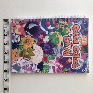 Image showing the width of the sticker book using a fabric ruler. It is 5.83 inches wide.