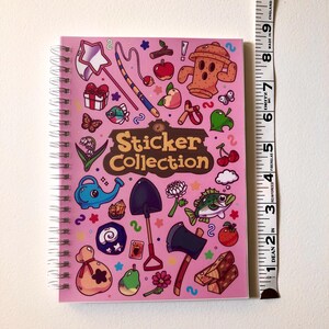 Image showcasing the length of the sticker book using a fabric ruler. It is roughly 8.27 inches long