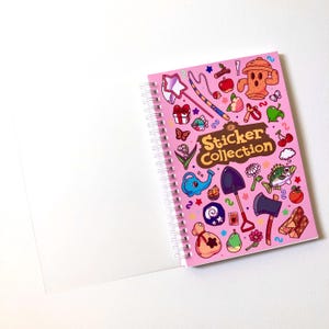 Image of the frosted clear protective plastic cover of the sticker book lying open to clearly see the decorative card-stock cover underneath.