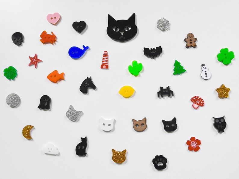 May include: Assortment of colorful and glittery buttons in various shapes, including animals, hearts, stars, and geometric designs.