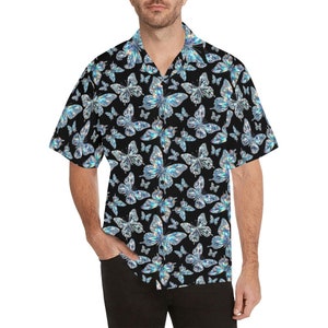 May include: Black button-down shirt with a repeating pattern of iridescent blue butterflies. The short-sleeved shirt has a classic collar and is made of a lightweight fabric. The butterfly design is eye-catching and detailed.