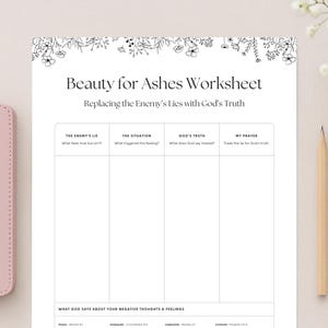 May include: A pink leather-bound Holy Bible rests beside a worksheet titled "Beauty for Ashes Worksheet." The worksheet, with floral accents, features sections for reflection and the text "Replacing the Enemy's Lies with God's Truth."