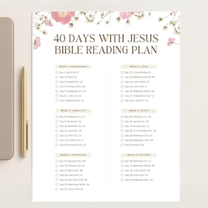 May include: A white Bible reading plan titled "40 Days With Jesus" with floral accents. The plan is divided into weeks with daily scripture references. A gold pen and a gray tablet are in the background.