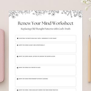 Puede incluir: Una Biblia rosa y una hoja de trabajo titulada "Renew Your Mind Worksheet" con indicaciones para la memorización de las Escrituras. También se ven un lápiz y detalles florales. Las indicaciones de la hoja de trabajo incluyen escribir versos lentamente.