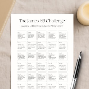May include: A beige Holy Bible rests beside a white paper with the text "The James 1:19 Challenge" and a 30-day challenge. A lit candle and a cup of coffee are also present. A black pen is on the right.