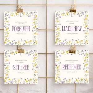以下が含まれることがあります： 金色の格子にクリップで留められた、花柄の縁取りとテキストが入った4枚の正方形のカード。「FORGIVEN」、「MADE NEW」、「SET FREE」、「REDEEMED」と紫色のテキストで書かれています。カードは黄色と紫の花で飾られています。