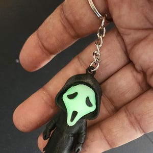 Chaveiro com rosto de fantasma 3D – Bolsa com pingente de máscara de filme de terror, acessório assustador que brilha no escuro para fãs de Halloween e filmes de terror