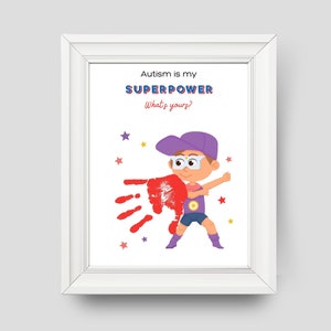 May include: A white framed print with a cartoon illustration of a boy wearing a purple hat and glasses, holding a red handprint. The text on the print reads "Autism is my SUPERPOWER What's yours?"