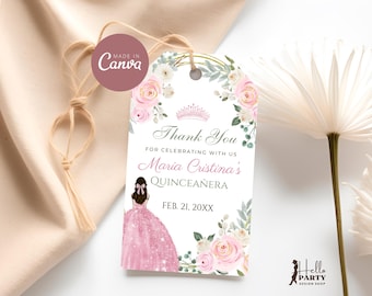 May include: A decorative tag with a floral design and the text "Thank You" for a Quinceañera. The tag features a pink dress illustration, a crown, and the date "FEB. 21, 20XX". The tag is tied with twine.