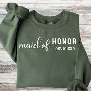 May include: A green sweatshirt with the text "maid of honor obviously" in white lettering.