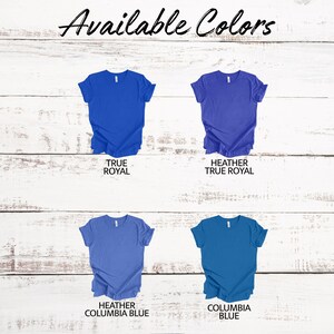 Op de afbeelding: Vier T-shirts in verschillende tinten blauw. De shirts liggen plat op een witte houten achtergrond. De kleuren zijn True Royal, Heather True Royal, Heather Columbia Blue en Columbia Blue.