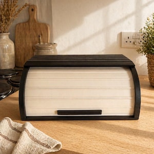 Panera de madera negra hecha a mano con tapa enrollable, ideal para guardar alimentos en la cocina de estilo rústico.